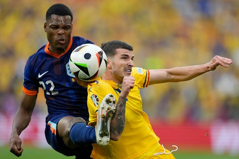 Denzel Dumfries fights for the ball against Valentin Mihaila